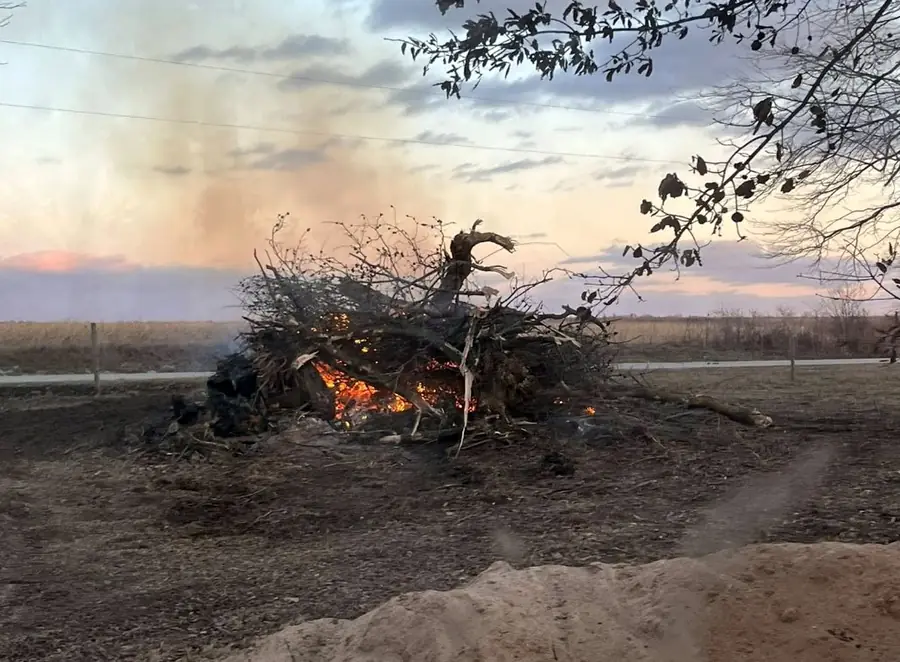 Brush pile burning at dusk on a cleared field