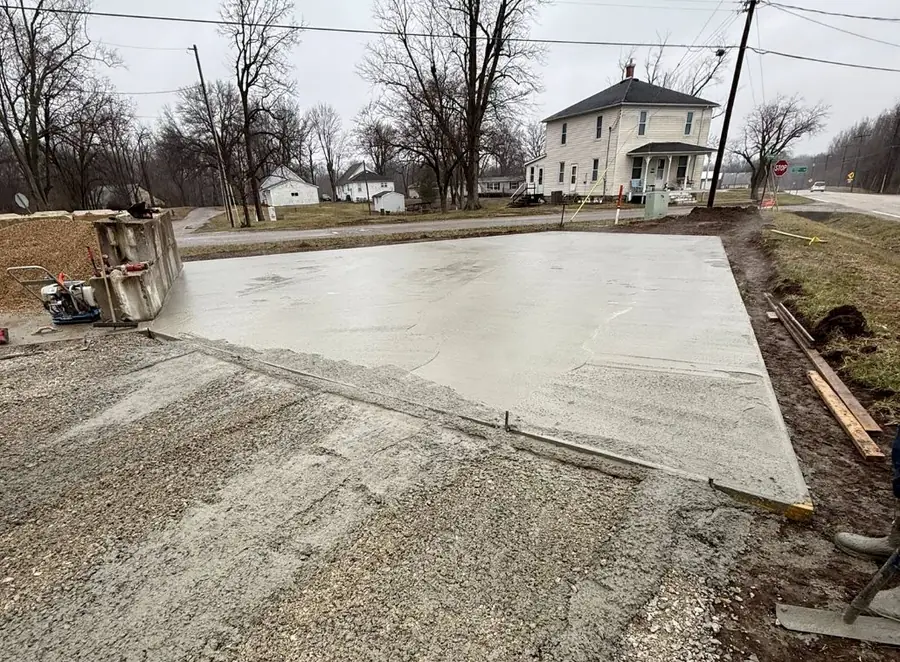 Poured concrete driveway beside a farmhouse