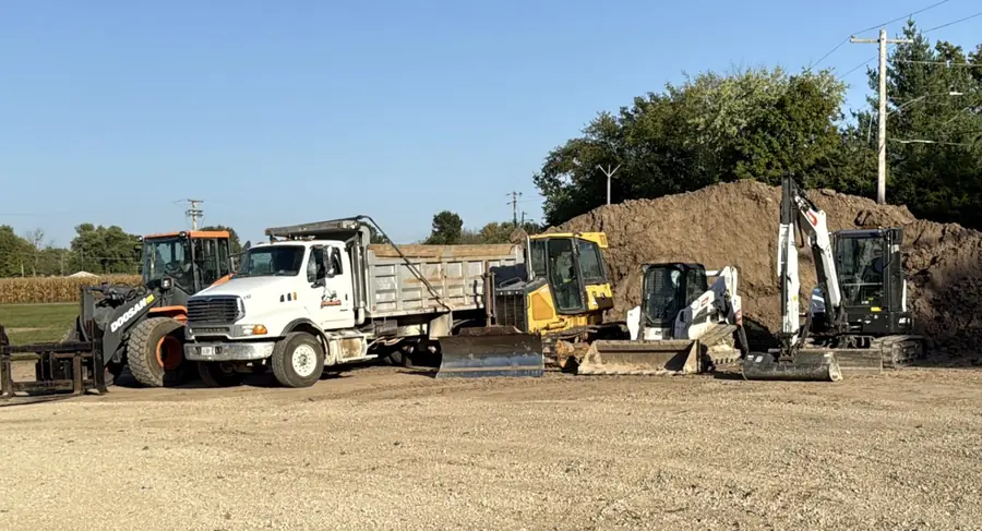 Dump truck and skid steer working dirt stockpiles