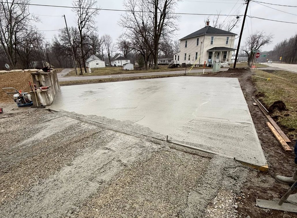 Poured concrete driveway beside a farmhouse