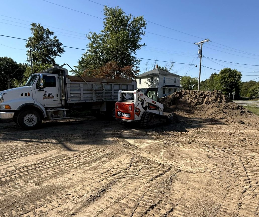 Dump truck and skid steer on a site